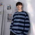 Male model wearing oversized blue striped telnyashka long sleeve shirt with relaxed fit