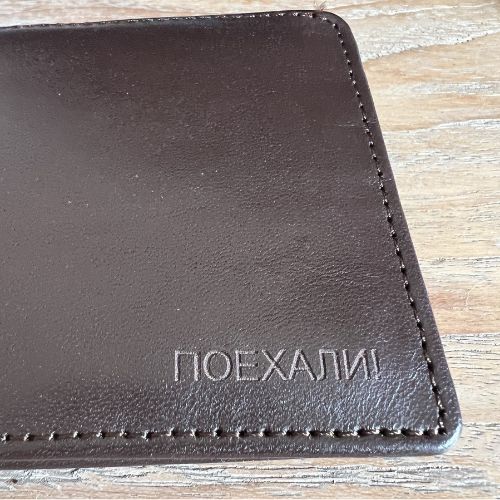 Close-up of the "Poyekhali" engraving on Yuri Gagarin Soviet leather wallet